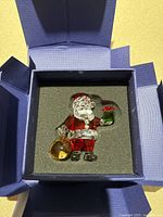 Swarovski Crystal Santa figurine in blue box with black foam insert.
