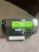 Top view of the vacuum sealer machine showing the green instruction label about the 2-in-1 vacuum sealing solution and some control buttons.