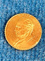 Close-up image of the gold medal showing the profile portrait of Josip Broz Tito with 'BROZ' inscribed around the edge.