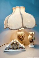Photo showing the entire set of vintage Aynsley clock, lamp with fabric shade, and vase on blue background