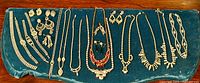 Full display of vintage rhinestone jewelry laid on blue velvet, depicting several necklaces, bracelets, and earrings arranged in a line for overview.