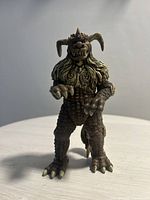 Front view of the King Caesar action figure showing detailed face, clawed hands, and textured legs.