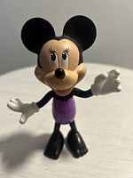 Front view of Minnie Mouse Snap 'n' Style figure showcasing face, ears, purple outfit, white gloves, and black shoes.