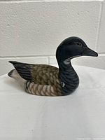 Side view of the wooden painted decoy duck showing detailed feather painting and duck profile