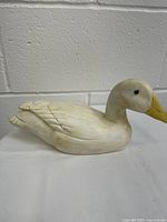 Full side view of the wooden painted duck decoy showing the carved feather details and shape.