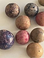 Close-up of nine clay marbles showing mottled surfaces