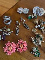 Overview of assorted earrings and brooches showing variety of materials and styles