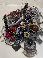 Overall pile showing assorted necklaces, bracelets, pendants and brooches