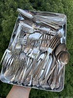 Tray containing assorted silver-plated forks and spoons