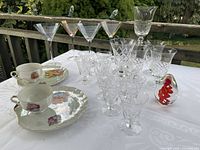 Group shot of all stemware, cups, saucer and paperweight on table