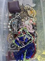 Overview of container filled with assorted jewelry pieces