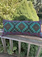 Full view of rectangular embroidered bolster on railing