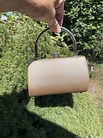 Front view of metallic gold hardbody evening bag with top metal handle