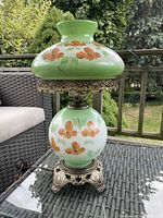 Full view of lamp showing top and bottom globes, metal collar, and base