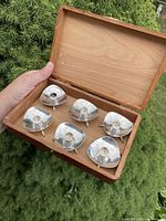 Six candlesticks in open wooden box