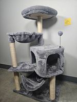 Full view of gray cat tree showing platforms, hammock, cubed hideout, and boingy ball on spring