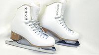 Full view of right and left white leather ice skates showing wooden heel and silver blades.