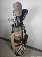 Golf clubs in a multi-pocket golf bag showing head covers and club organization