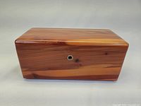 Front side view showing the cedar wood grain and keyhole on the jewelry chest.