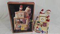 Lenox Christmas-themed cookie jar with original packaging showing Santa and stove with holiday motifs.