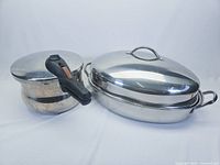 Pressure cooker and roasting pan with lid and rack, shown from the front on a white background.