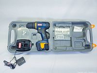 Full kit laid open in plastic carrying case showing cordless drill, charger, and bit set.