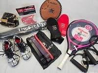 Full lot showing tennis racket, boys cleats, baseball gloves, helmet extension, and exercise bands.