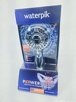 Front view of Waterpik PowerPulse showerhead in original packaging, showing product and branding details.