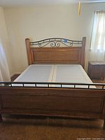 Full front view of king size wood and metal bed frame with split box springs placed inside.