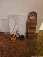 Photo showing all items: marble cutting board, wooden mortar and pestle, brass mortar and pestle, and wooden US Mail organizing rack.