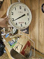 Detecto hanging produce scale showing large dial and metal bucket with cardboard box inside