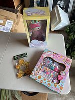 Overview photo showing Butterglow doll box, nail boutique toy set, and gingerbread photo frame on a table