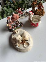 Front view of all items including nativity scenes, Santa on motorcycle, candle holder, and Indigenous figurine.