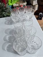 Top angled view of 12 crystal glasses, six stemmed Waterford crystal glasses and six tall tumblers with cut and etched patterns.