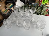 13 crystal stemware glasses on table: 7 tall at back, 6 short in front