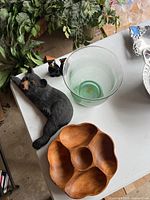 Overall view of black bear salt and pepper shakers, bear figurine serving tray, wooden divided bowl, and glass vase on white table