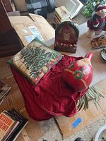 Overview of the holiday items including pillow, tree skirt, gourd, and napkin holder displayed on boxes and table