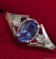 Close-up angled view of the ring focused on tanzanite and diamond stones.