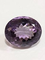 Front angled view of the amethyst gemstone showing faceted oval cut and purple color.