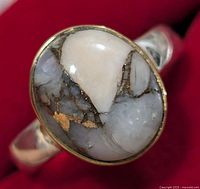 Close-up front angle of oval Muhave turquoise stone in silver ring setting.