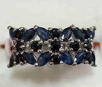 Front view of the silver ring with marquise and round cut blue sapphire stones arranged in rows.