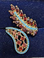 Close-up of the silver ring showing the turquoise beads and garnet stones in detail on a blue background.