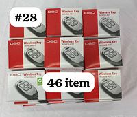 Stack of 46 boxed DSC WS4939-ADT wireless key fobs showing packaging.