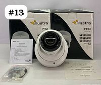 Two Illustra Pro Mini-Dome cameras shown with boxes, one camera out of box showing dome and lens, accessory pack with mounting hardware and manuals visible.