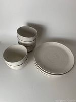 10 piece set of speckled small bowls and plates stacked side by side