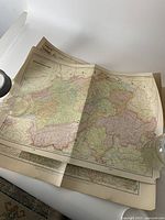 Photo showing a set of antique maps laid out with borders and various pastel colors indicating regions