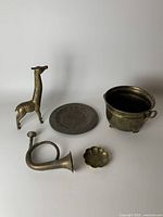 Overview photo showing the five brass items arranged on a white surface.