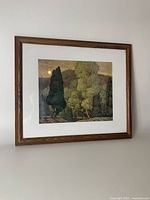 Framed Group of Seven print with landscape artwork, set in wooden frame with white matting.