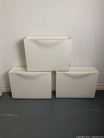 Front view of 3 white IKEA Trones shoe cabinets stacked in a pyramid shape, showing size and condition