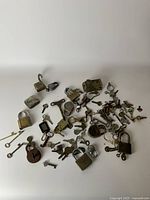 Collection of assorted metal keys and padlocks spread out showcasing variety in size and condition